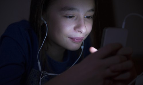 Teenager listening music on the bed